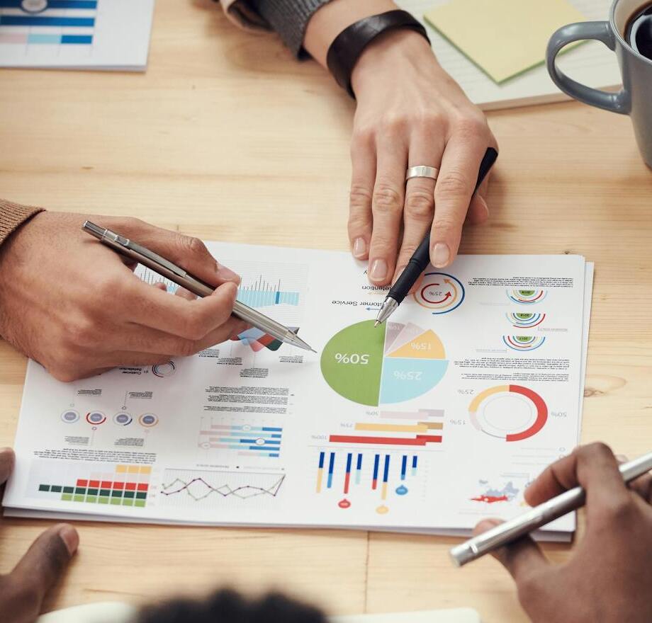 des mains pointent un graphique sur une feuille de papier